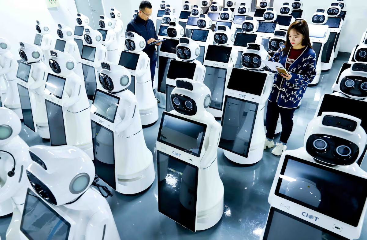 Dos empleados trabajan en una planta de ensamblaje de robots en Zhangye, en la provincia china de Gansu. VCG (VCG VIA GETTY IMAGES)